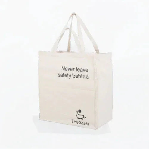 Product picture of TinySeats Totebag. It is cream white with a print stating Never leave safety behind. There is a TinySeats logo in the lower right corner.