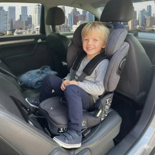 Older boy sitting rear-facing in a TinySeats Two with Singapore in the background. He has plenty of legroom.