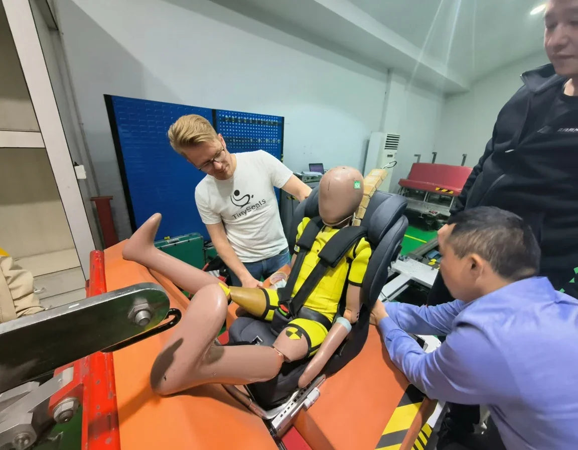 Crash dummy in a car seat with engineers  observing in a laboratory setting