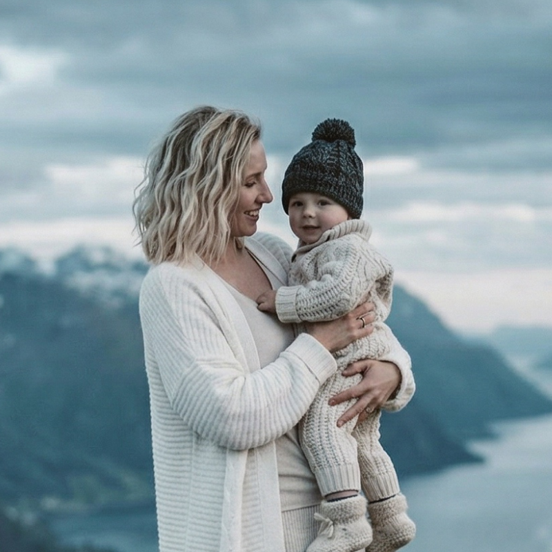 Woman holding a child against a mountainous background